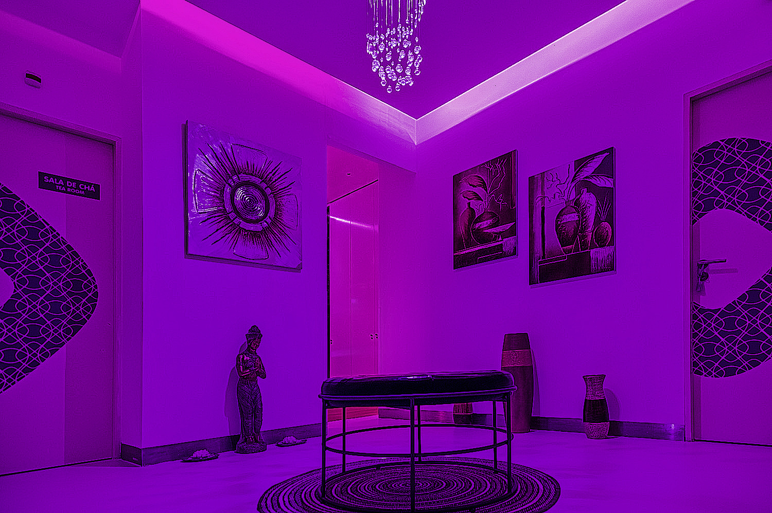 Sala de espera do Paradise Lisbon com decoração moderna e iluminação roxa.