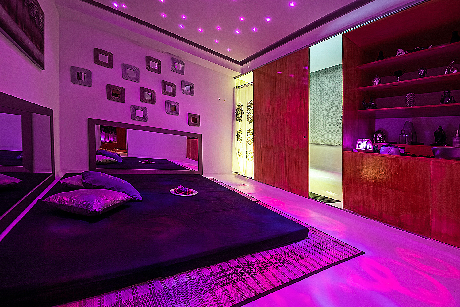 Sala de massagens relaxantes no Paradise Lisbon com iluminação roxa.