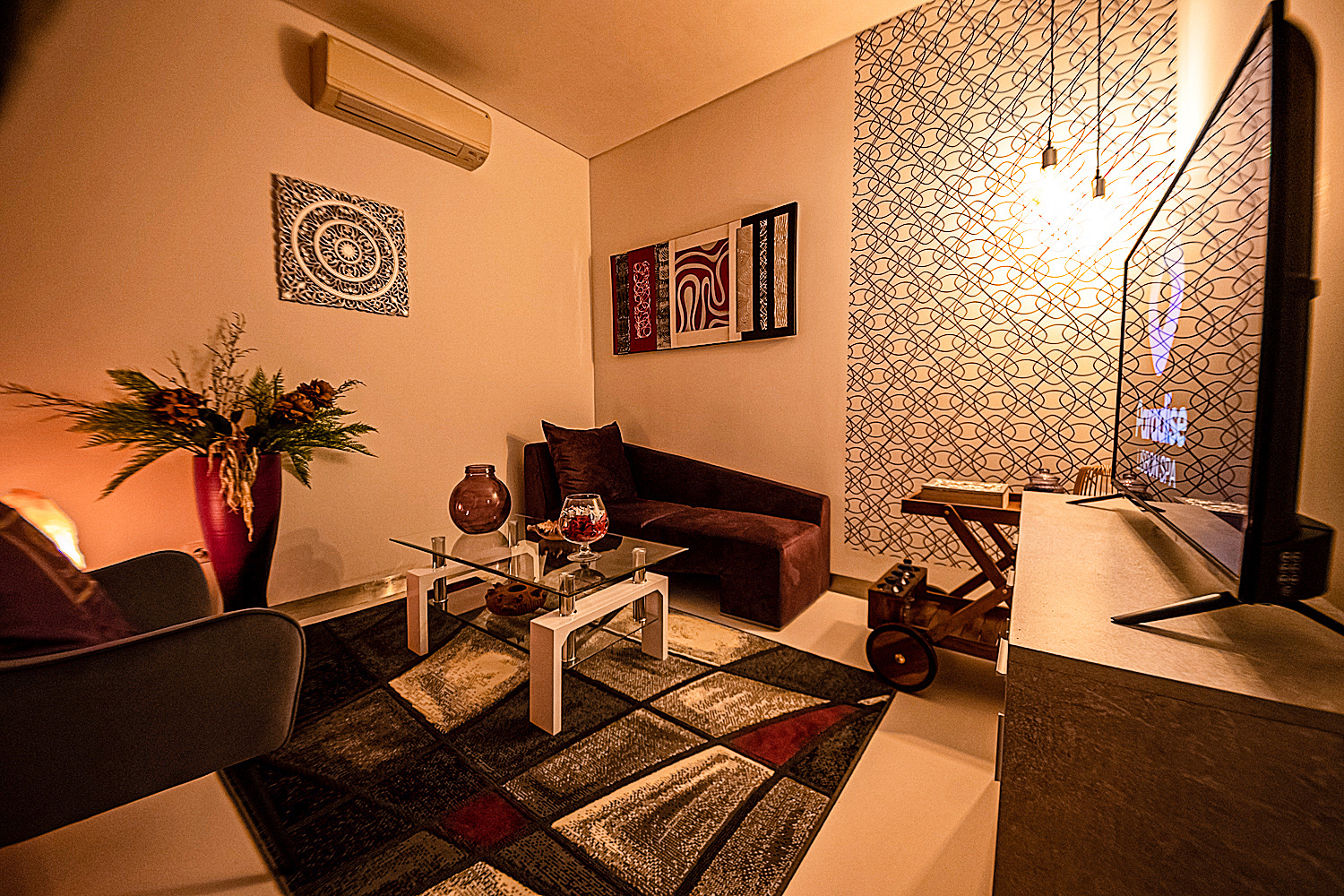 Sala de estar do Paradise Lisbon com sofás, mesa de centro e televisão.